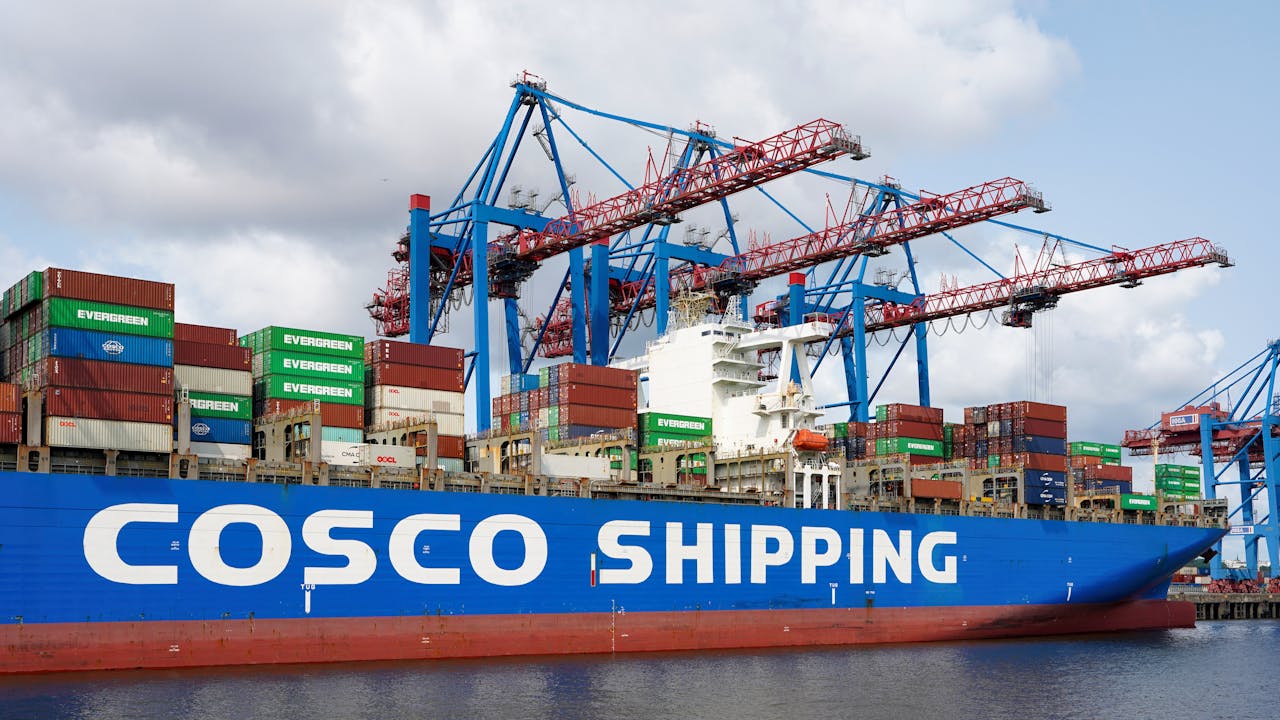 Crafting Captivating Headlines: Your awesome post title goes here Container ship COSCO at Hamburg port with cranes handling cargo.